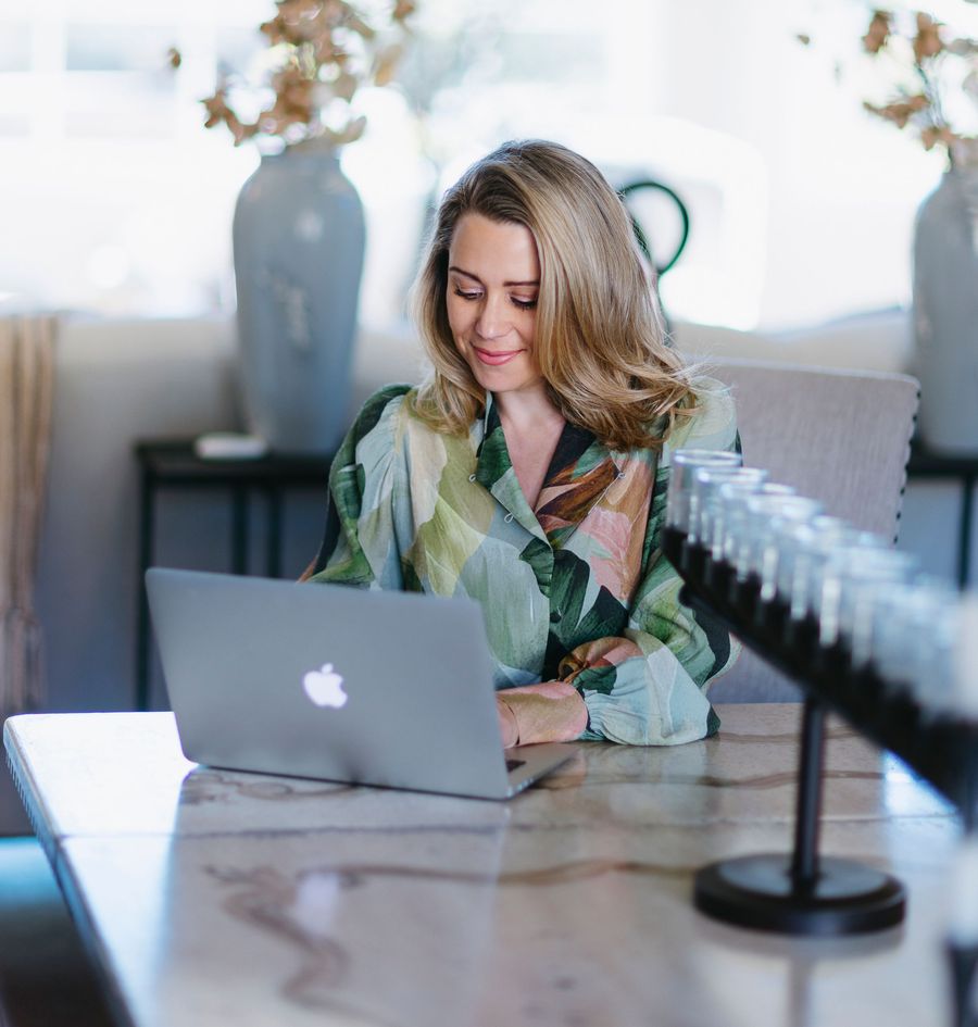 Anne Clare Lush working on her laptop at a dining table