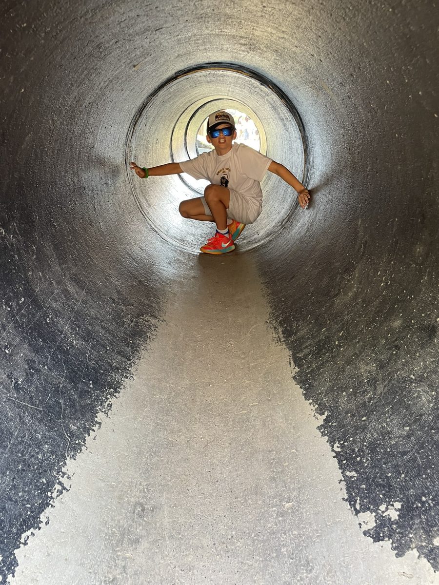 A boy in sunglasses crouching in the same tunnel in 2026