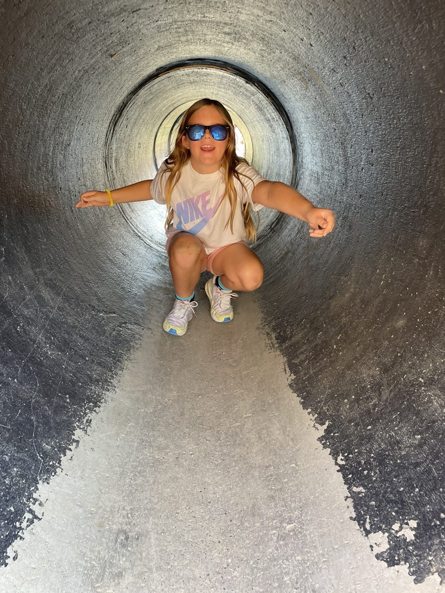 A girl in sunglasses crouching in the same tunnel in 2026